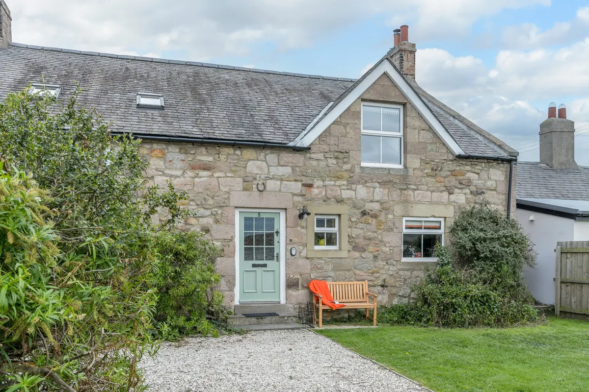 Stone cottage exterior with a garden bench