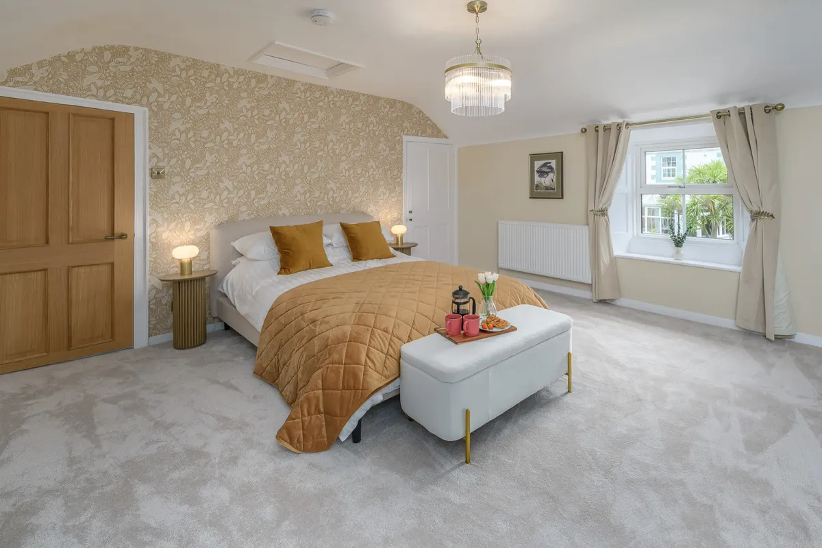 King-size bedroom with mustard bedding and a window seat