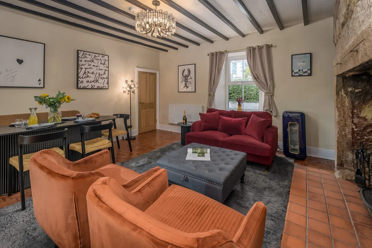 Family room with dining table, sofas and wood burner