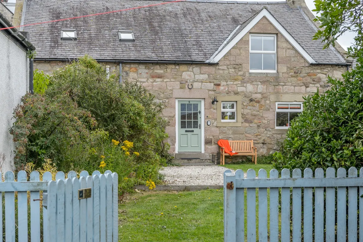 Cottage and front garden seen through the gate